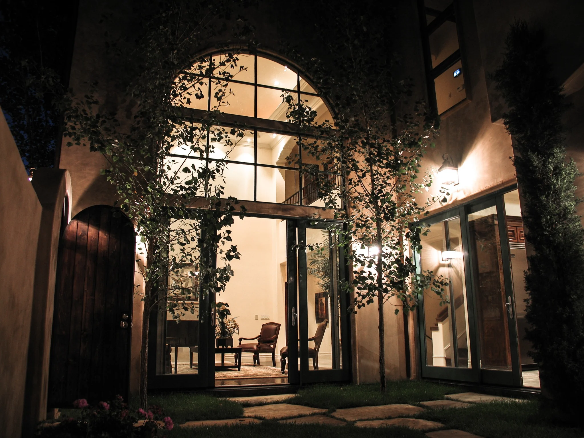 Illuminated arched garden glazing at night