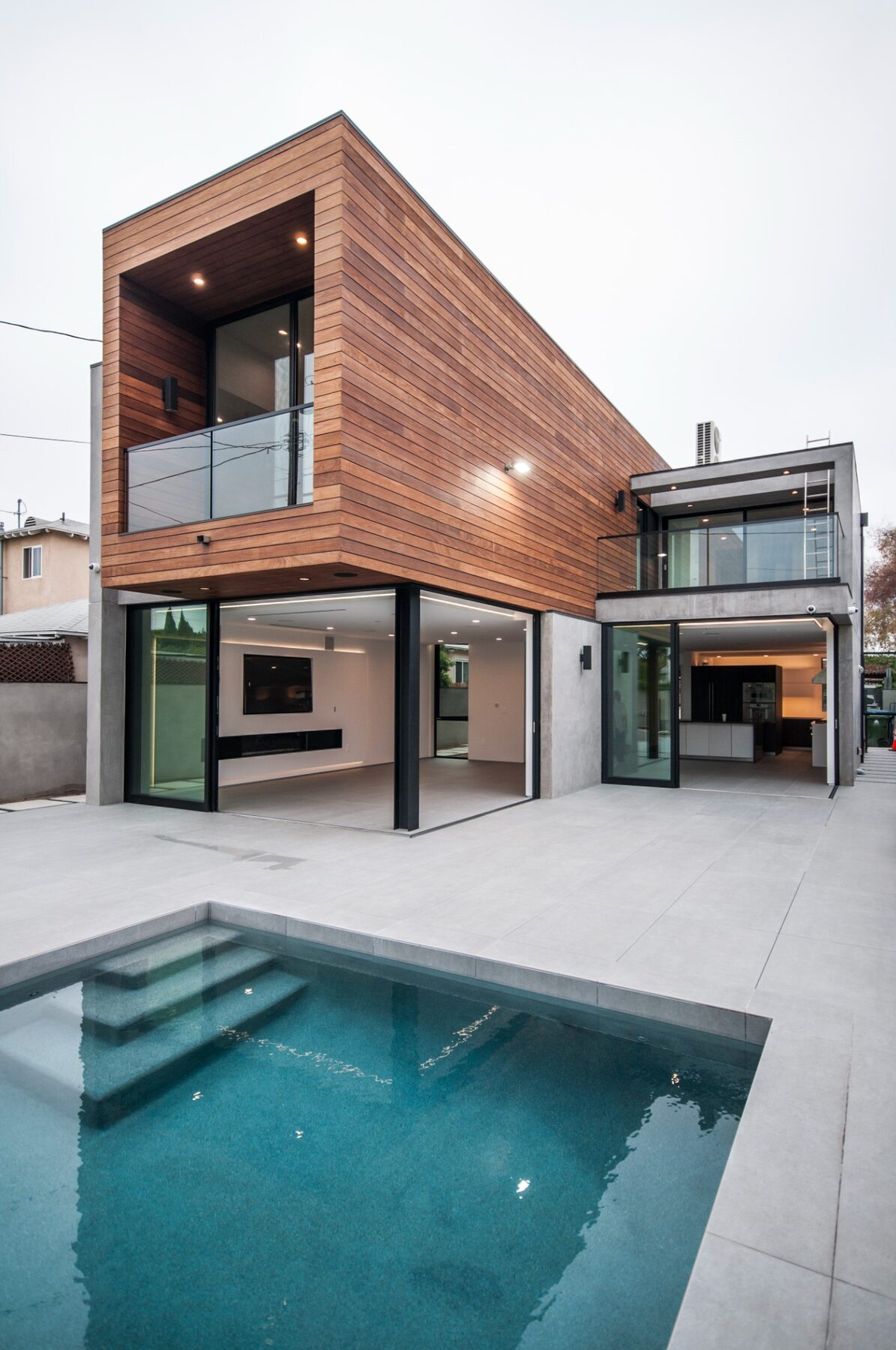 Built pool court and wood-clad upper volume