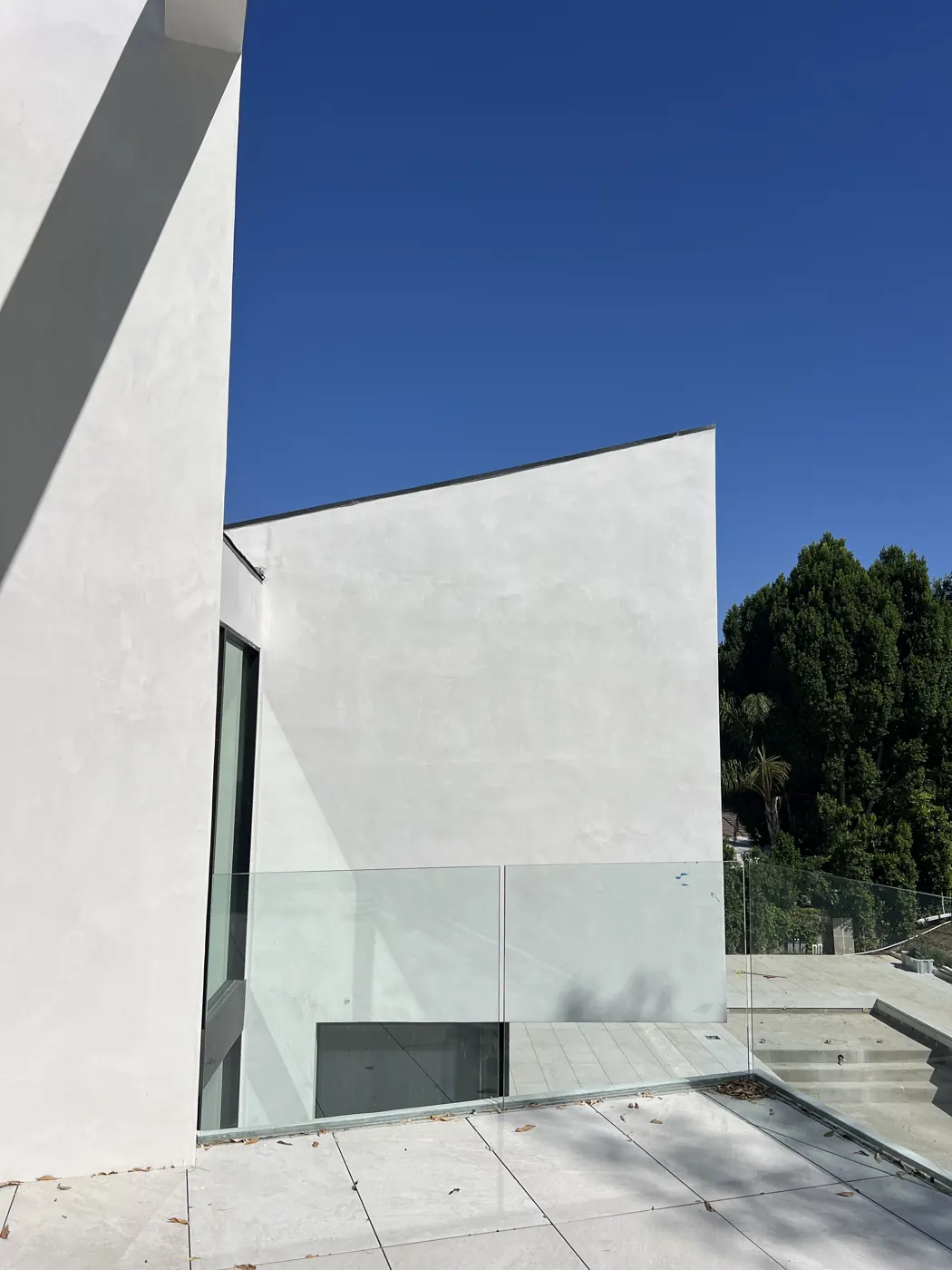 Projecting white volume with glass guardrail seen from below