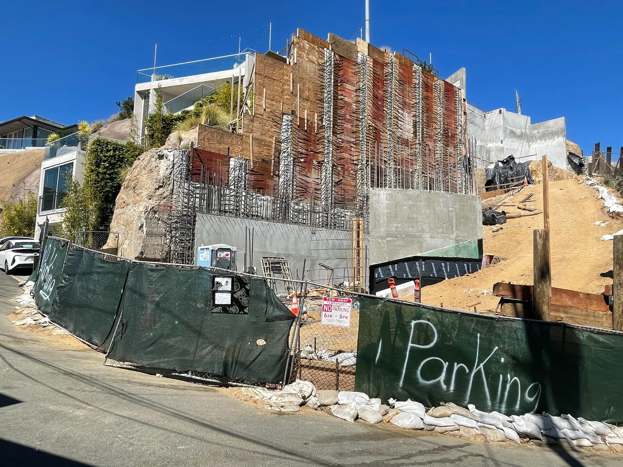 Shoring and reinforced-concrete construction at 8689 Franklin, with completed 8693 Franklin visible on the left