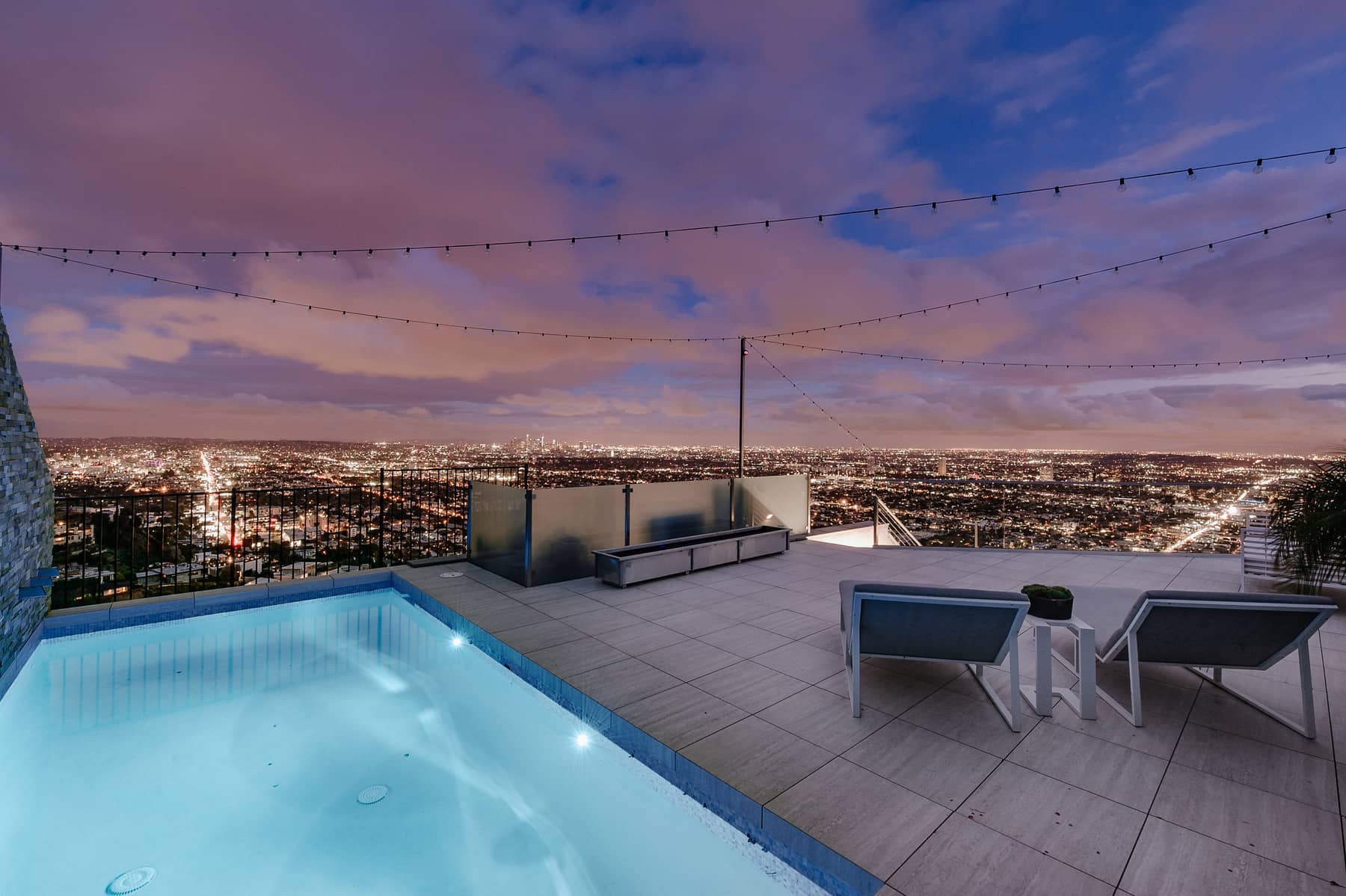 Illuminated pool terrace overlooking Los Angeles at twilight