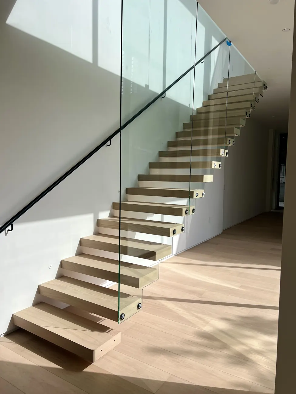 Open wood stair and glass guardrail in a Federal condominium