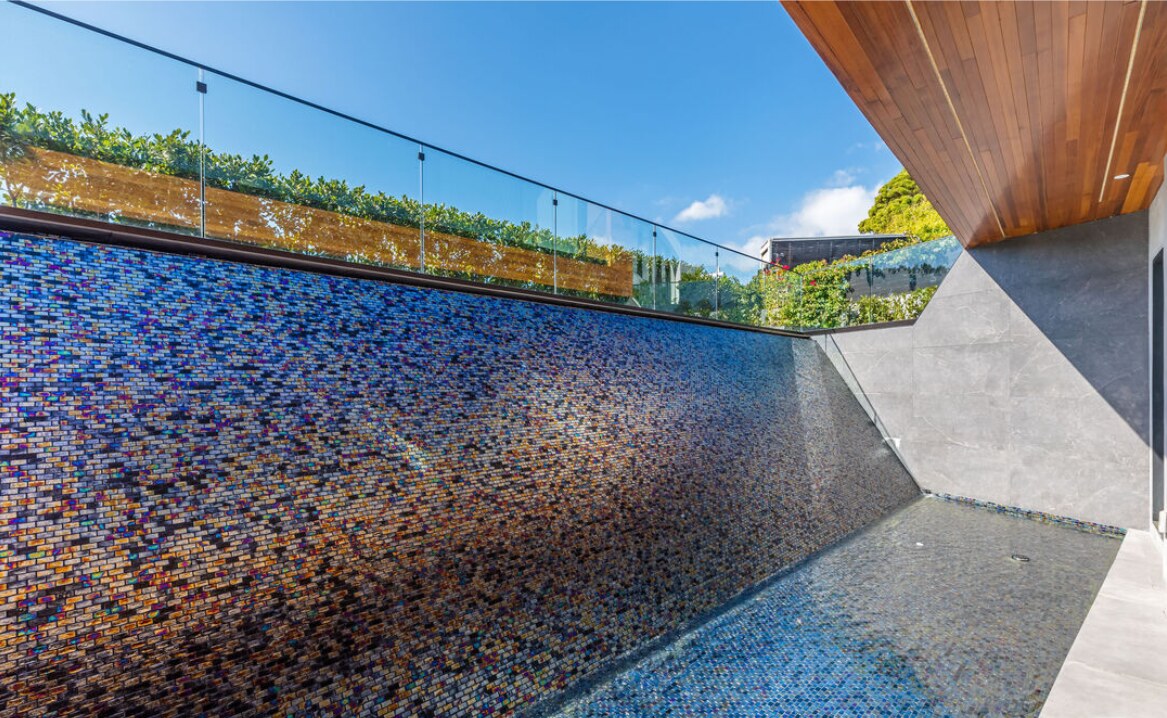 Detailed blue mosaic water wall beneath the terrace
